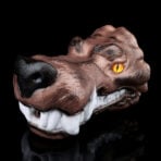 Monstrous brown dog head snarling with orange eye on a black background.
