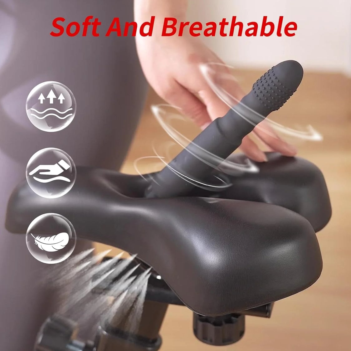 dildo_bike_seat_1_16b691b9-3230-41cb-ae87-b484a41d526d.jpg Close-up of a black silicone vibrator being positioned by a hand, with the red phrase 'Soft And Breathable' at the top and three circular icons on the left indicating softness, safety, and breathability.