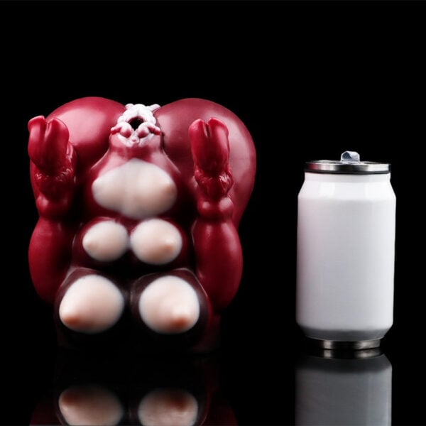Red abstract anatomical model with white nodules seated beside a white salt shaker on a black background, emphasizing scale and contrast.