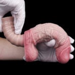 Close-up of gloved hands gently stretching an adult Silicone Realistic Dildo in a medical context.