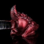 Red dragon head sculpture pierced by a clear glass tube through its anus on a reflective black surface, dramatic lighting.